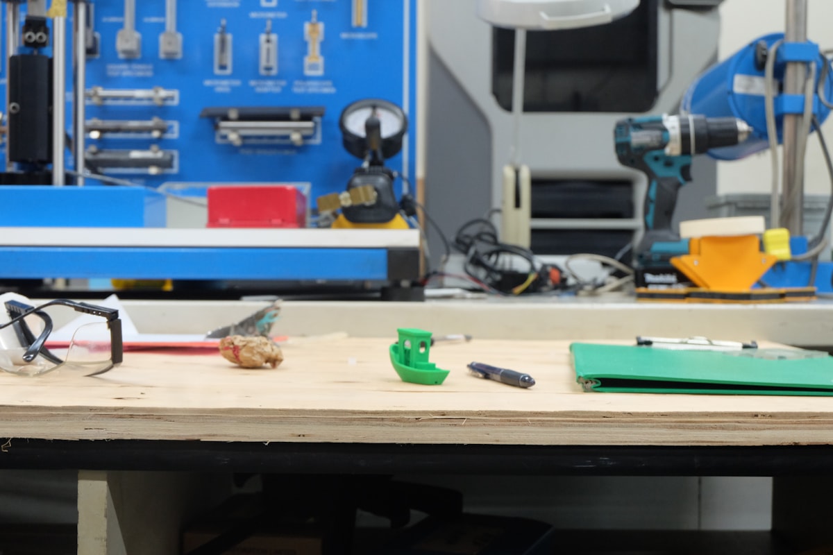 3D printed Benchy boat model on a workbench, a common test print for calibrating 3D printers
