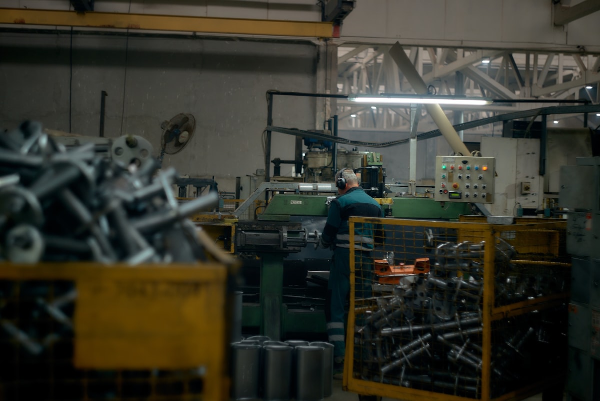 Worker operating precision manufacturing equipment in a modern factory setting